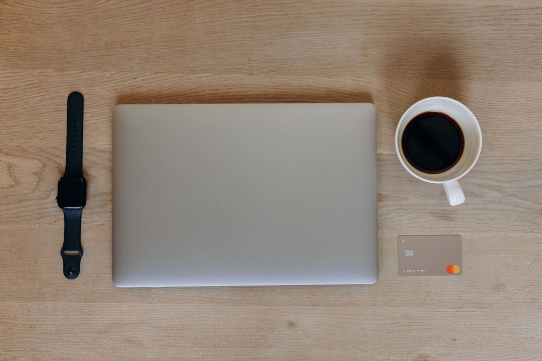 A credit card resting on a desk next to a notebook and pen